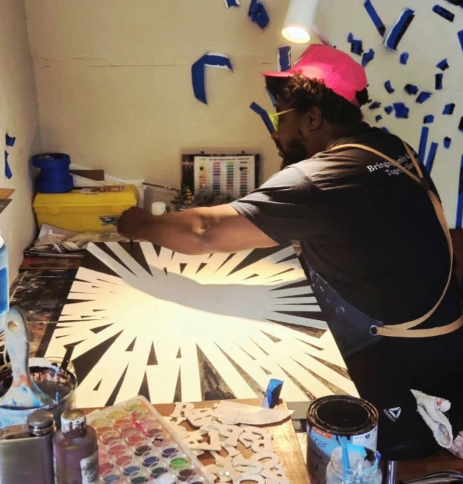 Keshida Layone at work on a large black and white painting in his studio